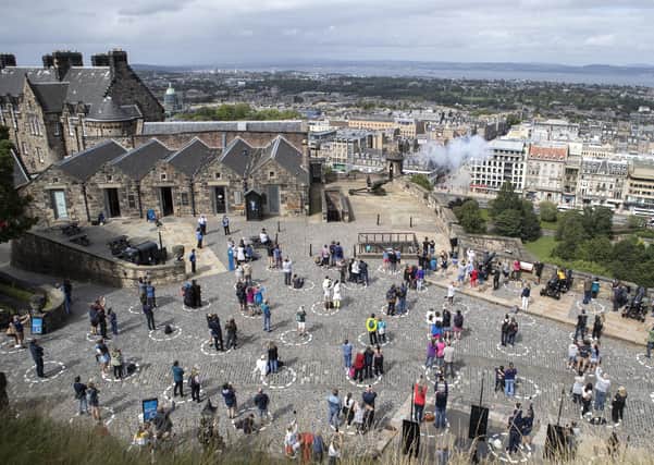 Visitors at Edinburgh Castle stand socially distanced in marked out circles as they watch the daily one o'clock gun ceremony as Scotland continues in Phase 3 of coronavirus lockdown restrictions, Thursday August 20