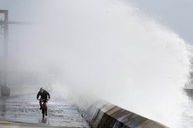 A cyclist is hit by a wave as he cycles along the shoreline in Saltcoats on the west coast of North Ayrshire as gusts of up to 70mph could hit coastal areas as Storm Ellen moves on and leaves more wet and windy weather in its wake.