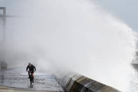 A cyclist is hit by a wave as he cycles along the shoreline in Saltcoats on the west coast of North Ayrshire as gusts of up to 70mph could hit coastal areas as Storm Ellen moves on and leaves more wet and windy weather in its wake.