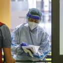 A medical worker wearing protective gear delivers a report of a COVID-19 test to a passenger of a flight from Valencia, Spain, at Rome's Ciampino airport. (AP Photo/Riccardo De Luca)