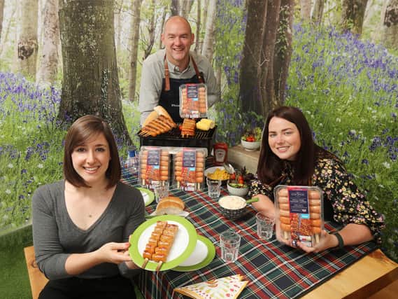 Emma Swan, Asda buying manager Northern Ireland, tries out the Extra Special Sausage Ladder with the help of John Cowen, Finnebrogue's account manager for Asda, and Sarah Savage, NPD manager at Finnebrogue