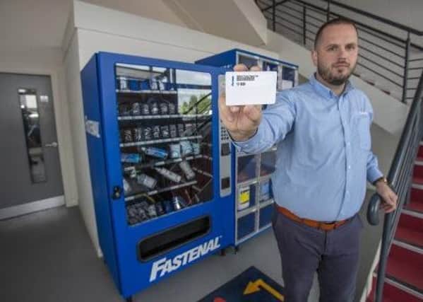 Jason Halberg, Fastenal's District Manager, demonstrates the contactless vending technology