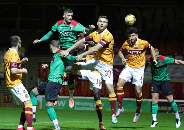 Glentoran's Rory Donnelly battles with Motherwell's Stephen O'Donnell. Pic by Pacemaker.