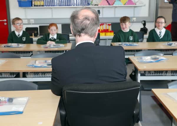 Education Minister Peter Weir, seen here with pupils at St Joseph's Primary School in Carryduff, faces a huge challenge in ensuring that children continue to be educated.