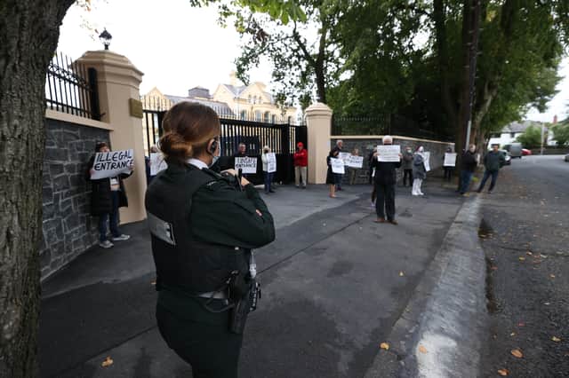 An officer from the PSNI watches residents during a protest outside the Chinese Consulate, Belfast, amid a dispute over the construction of a boundary wall and entrance gate which have been built without planning permission. Liam McBurney/PA Wire