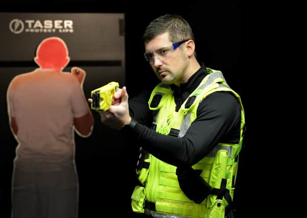 Tasers shoot out prongs which deliver an electric jolt; this is a Taser being demonstrated by an officer in northern England recently