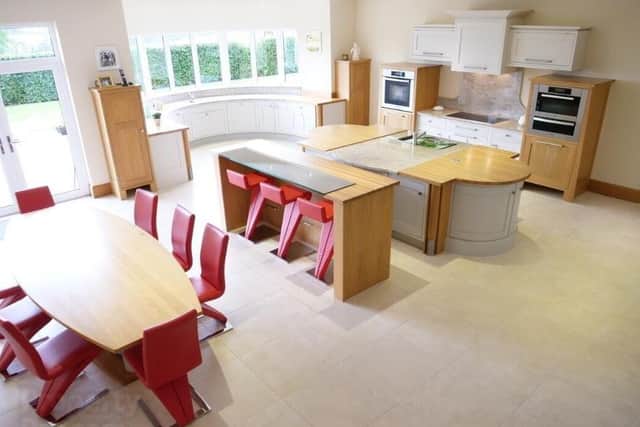 The kitchen with features including a breakfast bar, multiple integrated appliances, a crescent window and panoramic views