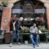 A customer is served a pint in the outdoor seating at Bittles Bar in Belfast city centre ahead of a new curfew for pubs