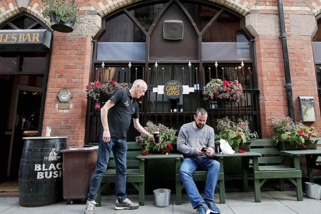 A customer is served a pint in the outdoor seating at Bittles Bar in Belfast city centre ahead of a new curfew for pubs