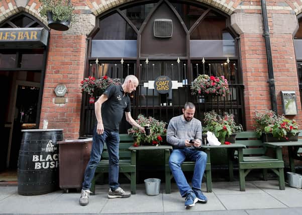 A customer is served a pint in the outdoor seating at Bittles Bar in Belfast city centre ahead of a new curfew for pubs