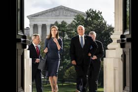 Judge Amy Coney Barrett, President Donald Trump's conservative nominee to the Supreme Court and Vice President Mike Pence arrive at the Capitol in Washington DC where she met with senators on Tuesday. The Supreme Court is seen behind (Erin Schaff/The New York Times via AP, Pool)