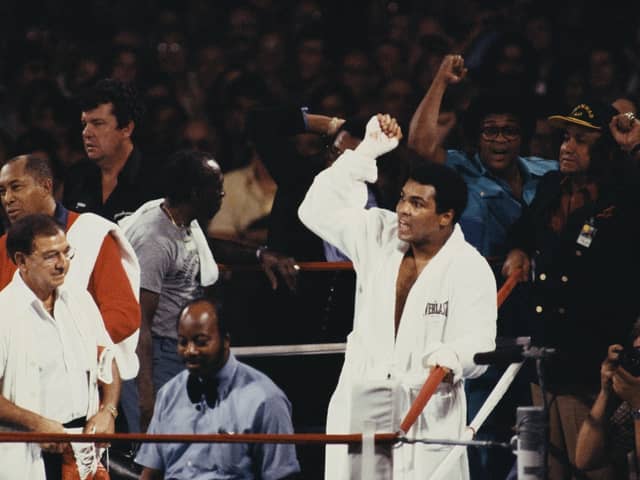 Muhammad Ali chants to the crowd and his opponent Larry Holmes as trainer Angelo Dundee (far left) looks on before the start of the WBC Heavyweight Championship bout on 2nd October 1980 at Caesars Palace, Las Vegas, Nevada, United States. (Photo by Steve Powell/Allsport/Getty Images).