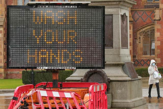 People pictured outside Queen's University in Belfast wearing face masks due to COVID-19