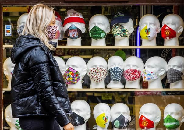A woman walks past a display of face coverings in Belfast