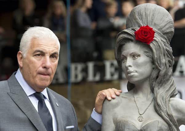 Mitch Winehouse next to a statue of his daughter following its unveiling on what would have been the singer's 31st birthday, at the Stables Market, Camden Town, London