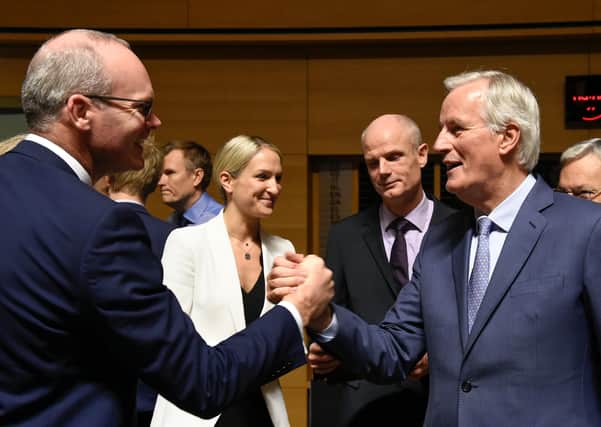 Irish Foreign Minister Simon Coveney shakes hands with European Union's chief Brexit negotiator Michel Barnier. Ireland has backed every instance of EU rigidity, when it could be urging the latter to compromise in the interests of a UK-EU deal.