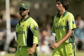 Pakistan cricketers Shoaib Akhtar (L) and Mohammad Asif walking together at a break during a practice match in Jaipur in October 2006. (Photo PRAKASH SINGH/AFP via Getty Images).