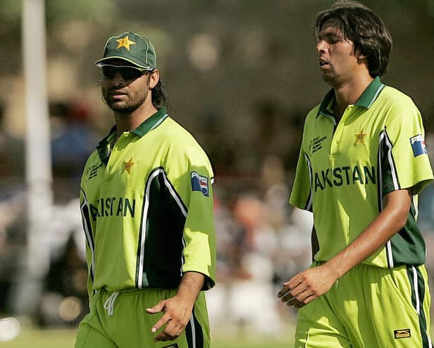 Pakistan cricketers Shoaib Akhtar (L) and Mohammad Asif walking together at a break during a practice match in Jaipur in October 2006. (Photo PRAKASH SINGH/AFP via Getty Images).