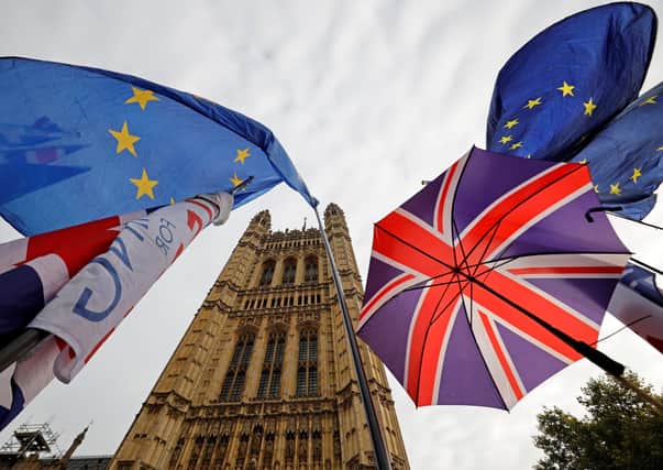 EU flag and Union flag-themed umbrellas of Brexit activists fly outside the Houses of Parliament in London on October 23, 2019