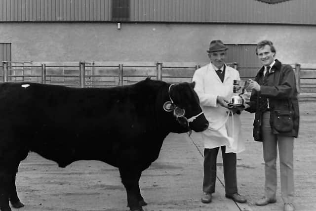 Laheens Berty was the supreme champion, at the first premier show and sale held by the Northern Ireland Aberdeen Angus Club in October 1987 which was held at Dungannon Farmers' Mart at Granville. The cow was owned by Fred Rea of Glarryford. Mr Rea is pictured receiving the championship award from Stephen Crawford, cattle adviser, John Thompson and Sons Ltd. Picture: Farming Life archives