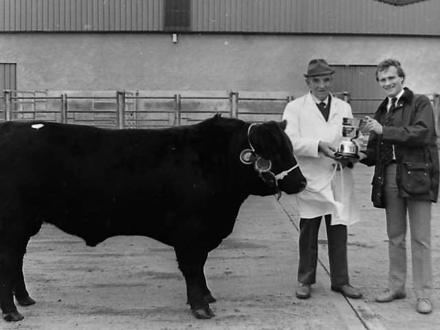 Laheens Berty was the supreme champion, at the first premier show and sale held by the Northern Ireland Aberdeen Angus Club in October 1987 which was held at Dungannon Farmers' Mart at Granville. The cow was owned by Fred Rea of Glarryford. Mr Rea is pictured receiving the championship award from Stephen Crawford, cattle adviser, John Thompson and Sons Ltd. Picture: Farming Life archives