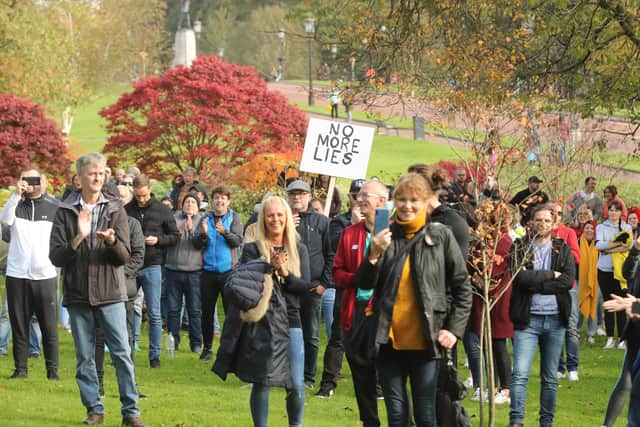 Anti-lockdown protesters, one holding a placard, on the Stormont estate in Belfast. PA Photo. Picture date: Sunday October 18, 2020. See PA story ULSTER Coronavirus. Photo credit should read: Niall Carson/PA/PA Wire