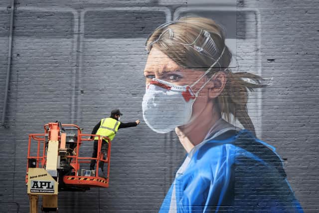Artist Peter Barber works on a mural in Manchester city centre, depicting nurse Melanie Senior, after The National Portrait Gallery commissioned the mural based on a photograph by Johannah Churchill