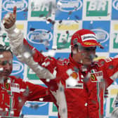Finnish Formula One driver Kimi Raikkonen (C) celebrates winning the F1 world title with  Ferrari team mananger Jean Todt (L) and Fernando Alonso at the Interlagos racetrack in Sao Paulo, Brazil 2007. Picture: AFP via Getty Images.