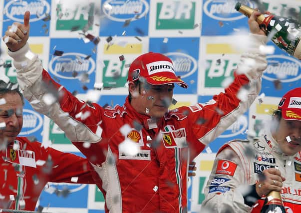 Finnish Formula One driver Kimi Raikkonen (C) celebrates winning the F1 world title with  Ferrari team mananger Jean Todt (L) and Fernando Alonso at the Interlagos racetrack in Sao Paulo, Brazil 2007. Picture: AFP via Getty Images.