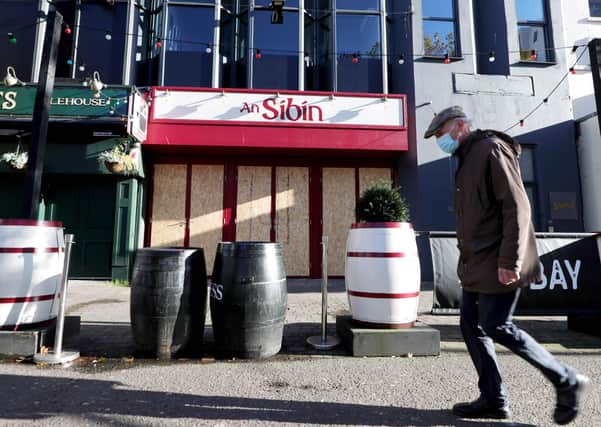 A lone pedestrian walks past shuttered businesses in Belfast city centre