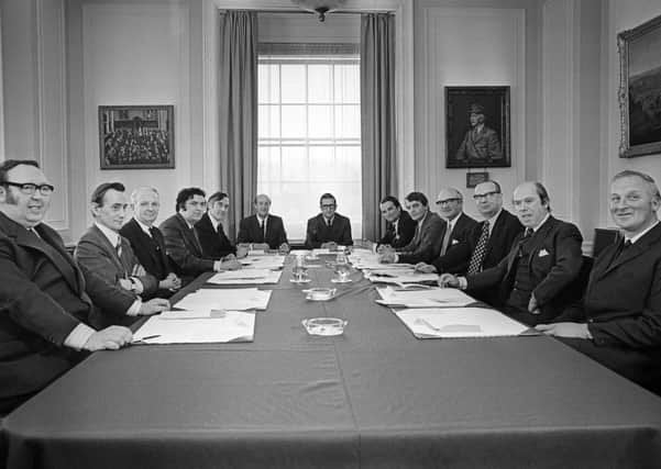The first official meeting of the new power sharing executive of 1974. (From left) Paddy Devlin (SDLP); Oliver Napier (Alliance Party); Brian Faulkner (Unionist) chief minister; John Hume (SDLP); Basil McIvor (Unionist); P.A. Sythes, assistant secretary; Ken Bloomfield, secretary; John Baxter (Unionist); Austin Currie (SDLP); Herbert Kirk (Unionist); Gerry Fitt (SDLP), deputy chief; Roy Bradford (Unionist); and Leslie Morrell (Unionist)