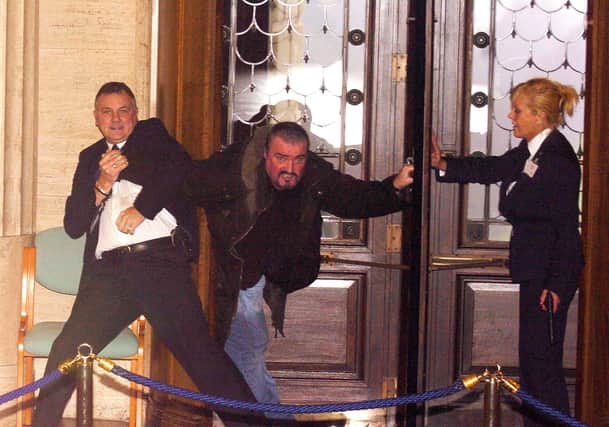 Michael Stone is tackled by security officers as he enters Stormont in 2006