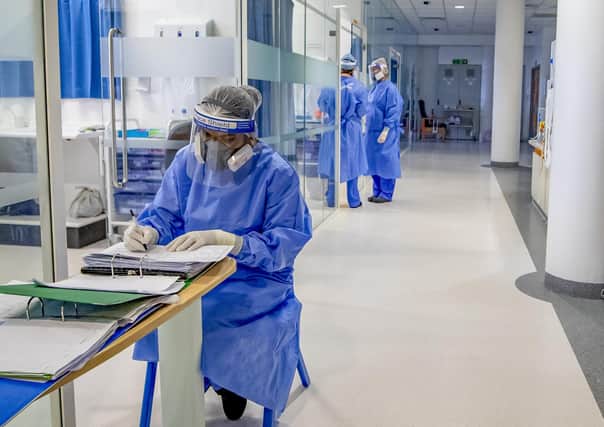Health workers wearing full personal protective equipment (PPE) on the intensive care unit (ICU) of an NHS hospital