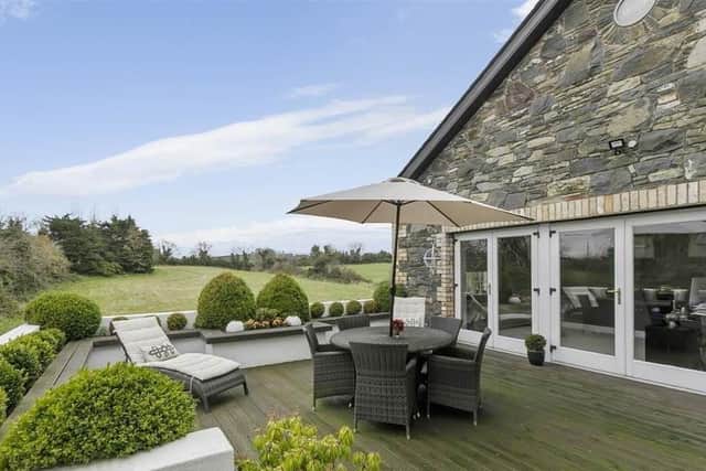 Exterior features include a paved patio and large feature decking area