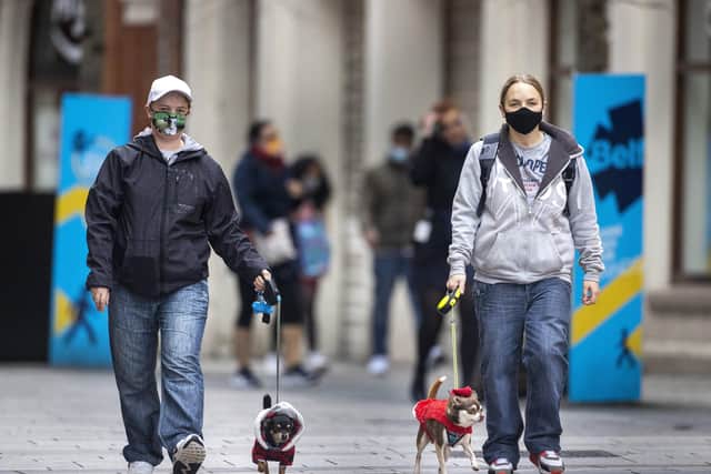 Emma Dodds (left) with TommyAlly (correct spelling) and Elizabeth Williams with Milo, wearing face masks, walk their dogs wearing Santa outfits through Belfast city centre.