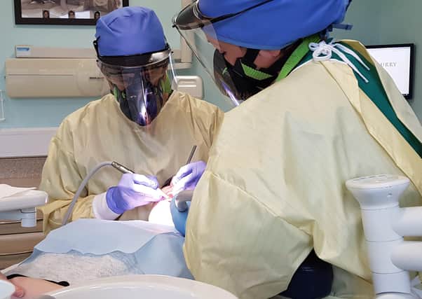 A dentist in full PPE gear during the coronavirus pandemic. They report that enhanced PPE such as this is exhausting to wear as it is so restrictive on breathing.