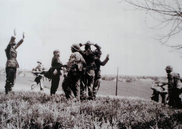 Belfast man Teddy Dixon (centre with gun) captures on of the SS guards fleeing Dachau concentration camp in April 1945