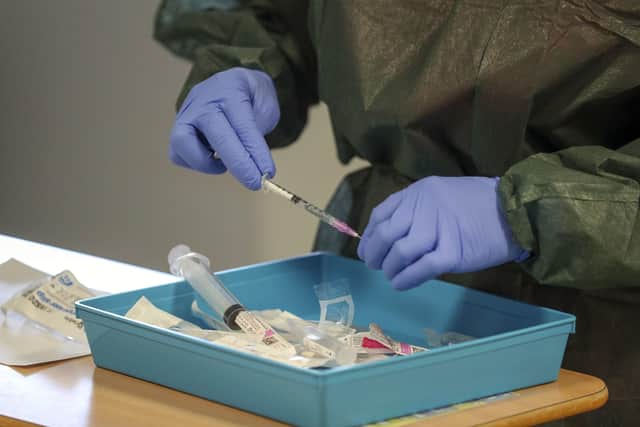 A nurse prepares an injection for a patient suffering from coronavirus on an Intensive Care ward