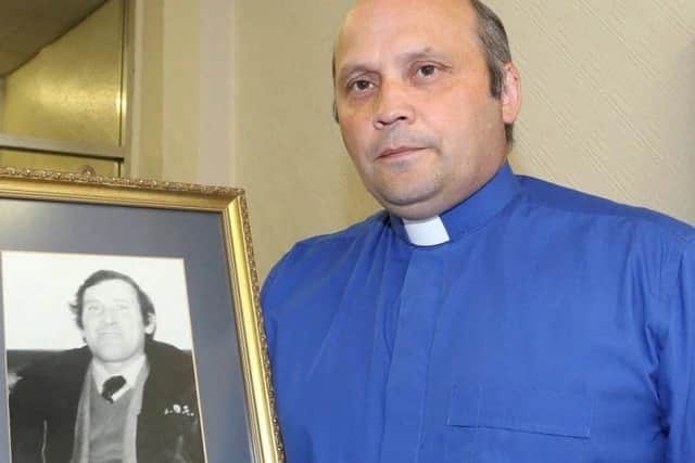 Rev Alan Irwin with a picture of his murdered father Thomas