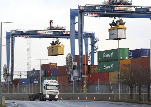Shipping containers are lifted to be transported at Belfast Harbour in Northern Ireland, Tuesday, Dec. 8, 2020. Britain and the European Union on Tuesday solved one thorny problem in their divorce, the status of Northern Ireland, but warned that the chances of a post-Brexit trade deal by a year-end deadline is slipping away. Britain is due to leave the EUÕs economic structures on Jan, 1. (AP Photo/Peter Morrison)