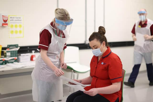 Emergency nurse practitioner Carly Niblock (left) reads over advice information documents with Sister Joanna Sloan before she becomes the first person in Northern Ireland to receive the first of two Pfizer/BioNTech Covid-19 vaccine jabs, at the Royal Victoria Hospital, in Belfast, on the first day of the largest immunisation programme in the UK's history