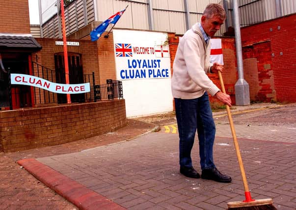 August 2005: A Local resident cleans up after about 400 nationalists and loyalists clashed during rioting in Cluan Place and Clandeboye Gardens in east Belfast