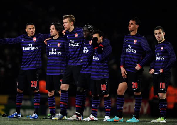 A dejected Arsenal team look on as they head out of the competition in the penalty shootout during the Capital One Cup quarter final match against Bradford City at Valley Parade on December 11, 2012.  (Photo by Laurence Griffiths/Getty Images).
