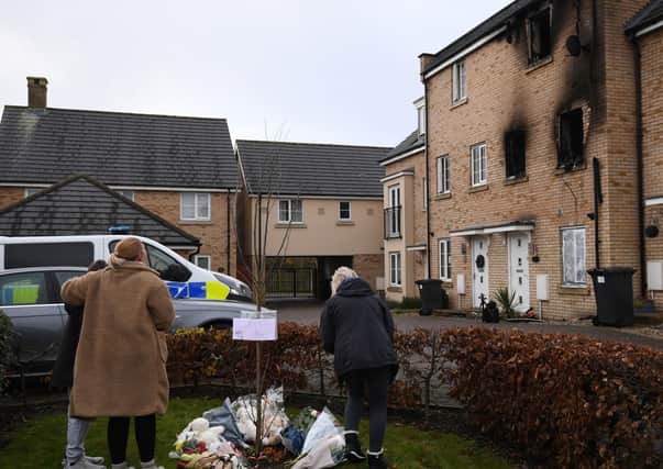 People lay flowers at the scene of a house fire on Buttercup Avenue, Eynesbury, Cambridgeshire, in which a three-year-old boy and a seven-year-old girl died. Photo: Joe Giddens/PA Wire