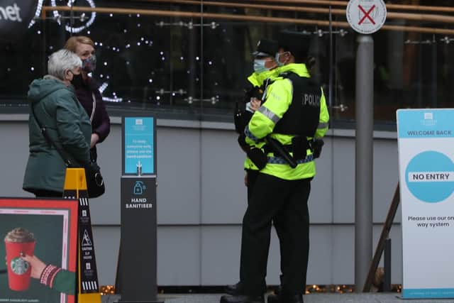 PSNI officers speak with members of the public outside a shopping centre in Belfast city centre as businesses across Northern Ireland re-open their doors following a two-week circuit-breaker lockdown aimed at stemming the spread of coronavirus.