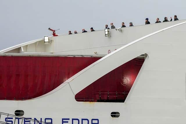 Passengers look out from Stena Line's Irish sea ferry Stena Edda at the company's River Mersey Birkenhead terminal after 322 passengers were stranded on the ferry overnight after crew members tested positive for Covid-19. (Photo: Christopher Furlong/Getty Images)