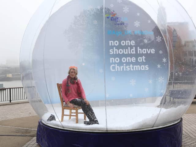 The model and fitness expert Diana Moran sits in a large snow globe to raise awareness of Age UK’s 2019 loneliness campaign. Christmas can be the loneliest time of year