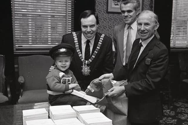 Pictured in December 1988 is two year old Mark Dodds helps his father, Nigel Dodds, the Lord Mayor of Belfast, put a differeny stamp on the traditional City Hall ceremony of posting early for Christmas, with the collective help of district head postmaster Stan Craig and postman Freddie Fisher. Picture: News Letter archives