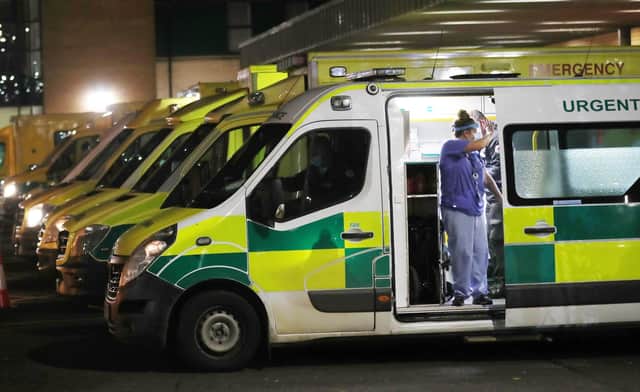 A nurse at Antrim Area Hospital waves to a patient who was waiting to be admitted in one of the rows of ambulances in the car park earlier this week.