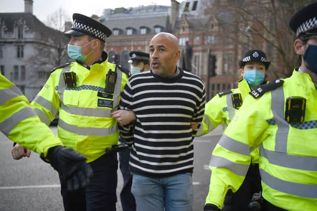 Police lead a man away during an anti-lockdown protest in Parliament Square central London. Pic: PA